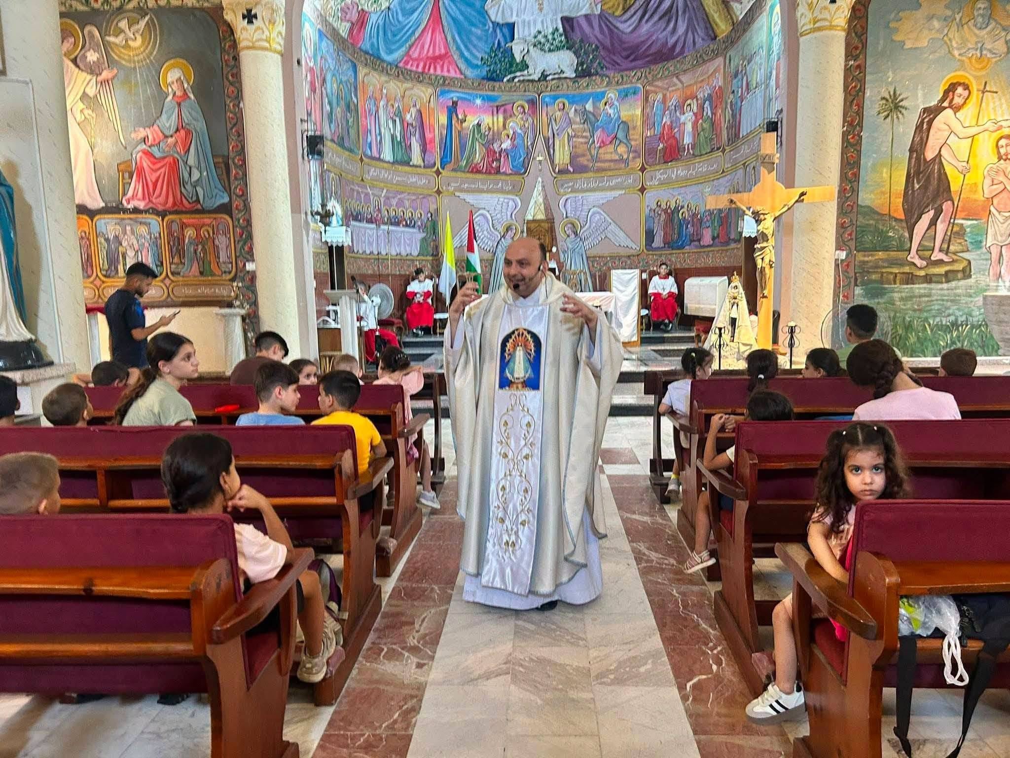 Copii adunați în biserica parohiei latine Sfânta Familie din Gaza, cu un preot